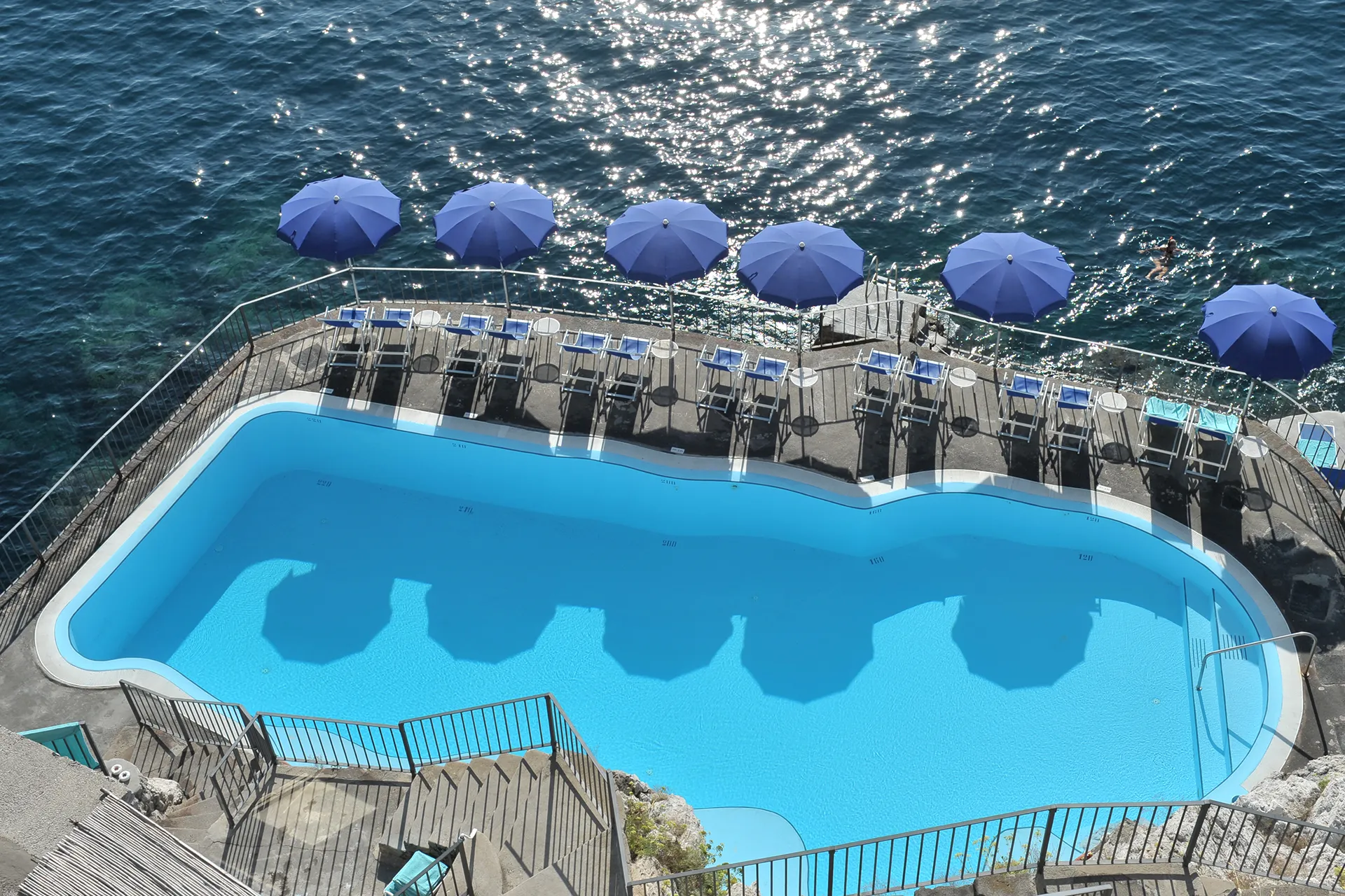Ospiti che si rilassano sul solarium della piscina – Hotel Luna Convento